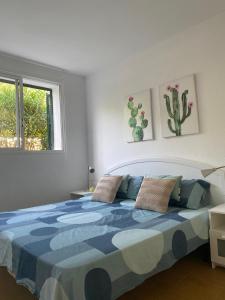 埃斯·梅卡达尔Coves Noves Nice apartment of 75 m2 10 minutes walk from the beach of Arenal d'en Castell的一间卧室配有一张带蓝色和白色棉被的床