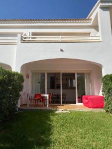 埃斯·梅卡达尔Coves Noves Nice apartment of 75 m2 10 minutes walk from the beach of Arenal d'en Castell的白色的房子,设有配有桌椅的庭院