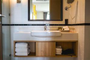 清迈Brique Suite的浴室配有盥洗盆、镜子和毛巾
