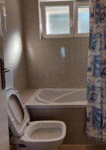 德雷斯Villa Wind Apartments的一间带卫生间和浴缸的浴室