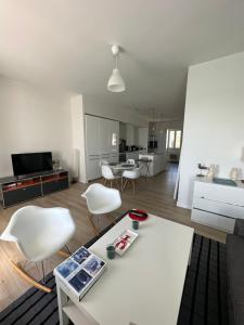 杜瓦讷内Appartement Design I - Port du Rosmeur - Douarnenez的客厅配有桌子和白色椅子