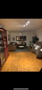 吕勒奥Charming room with big bed的客厅铺有木地板,客厅配有沙发。