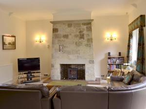 Saint LawrenceWestgate Cottage的带沙发和石制壁炉的客厅