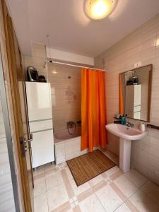 RianjoPiso WiFi en Rianxo的浴室设有橙色淋浴帘和水槽