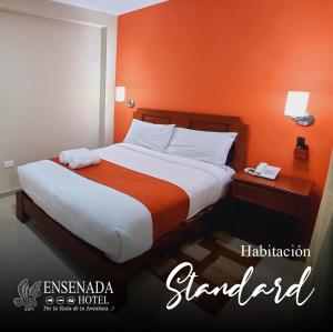 圣胡安Ensenada Hotel的一间卧室配有一张带橙色墙壁的大床