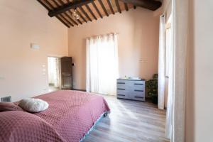 科尔托纳Casale Il Terranova的一间卧室配有一张床、一个梳妆台和一扇窗户。
