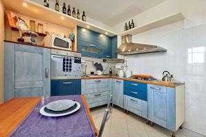 Borgo TicinoLe Betulle的厨房配有蓝色橱柜和木桌