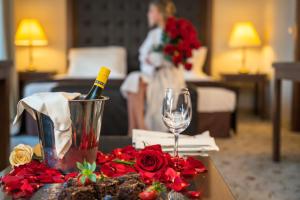 韦林格勒Maxi Park Hotel & Spa的一张桌子,上面放着一瓶葡萄酒和鲜花