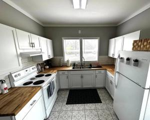 HamiltonMrs. Hughes Cottage - 2 bedroom House w/ parking的厨房配有白色橱柜和白色冰箱。