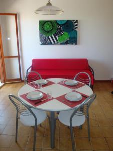 丽都阿德里亚诺奥罗拉住宅酒店的一张桌子、四把椅子和一张红色的沙发