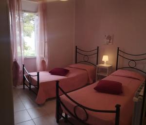 卡波利韦里La casa dei nonni的一间卧室设有两张带红色床单的床和窗户。