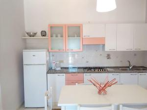 卡波利韦里La casa dei nonni的厨房配有白色冰箱和白色桌子