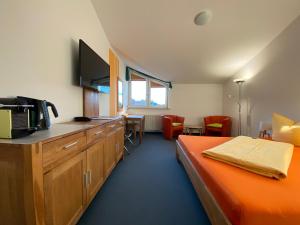 吕本瑙斯普利森林北欧酒店的一间设有床铺的客房和一间带微波炉的厨房
