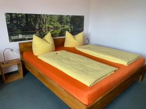 吕本瑙斯普利森林北欧酒店的两张带黄色和橙色床单的床