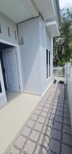 HalanganHOMESTAY PANDAN的白色的房子,设有门和瓷砖地板