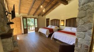 萨卡特兰Cabañas La Cascada的一间卧室设有两张床和石墙