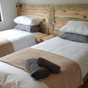 杰弗里湾JBay Surfed Out的一间卧室配有两张床,床上配有毛巾