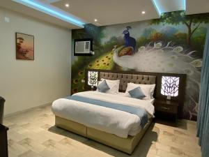 塔诺马أزد للشقق المخدومة的卧室配有一张大床,墙上挂有孔雀画