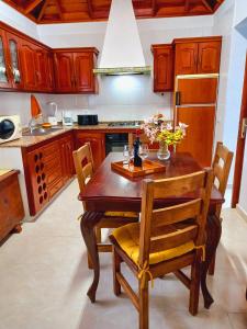 马佐La casa de Isabel的厨房配有木桌、椅子和冰箱