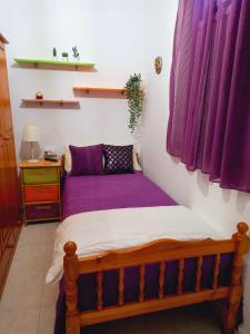 马佐La casa de Isabel的紫色床单间的一张床位