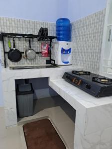 HalanganHOMESTAY PANDAN的厨房柜台设有水槽和炉灶。