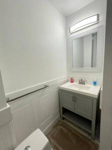 费城2bd Spacious S. Philly Row-House, Wi-Fi & 1.5 bath的白色的浴室设有水槽和镜子