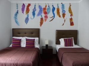 利马灯塔住宿加早餐旅馆的卧室配有两张挂在墙上的羽毛床。