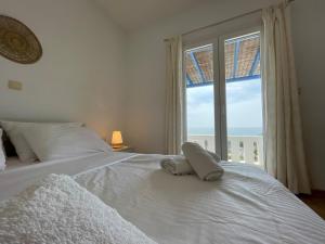 圣彼得罗斯Villa Maniati Studios的卧室配有白色的床和大窗户