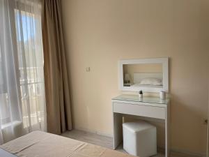 瓦尔纳Deluxe Apartment Varna South Bay Beach Residence的一间卧室配有一张床和一张带镜子的桌子