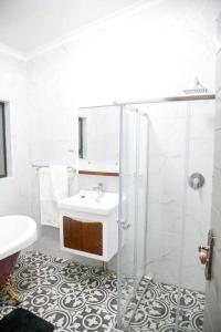 哈博罗内modern, two-story luxury house的白色的浴室设有水槽和淋浴。