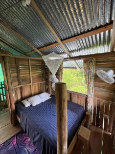 Palmar NorteLa Muñequita Lodge 1 - culture & nature experience的木屋内的卧室配有一张床