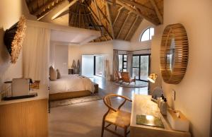 荆棘丛自然保护区Serondella Game Lodge的一间卧室设有一张床和一间客厅。