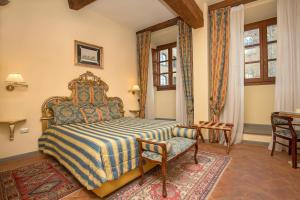 佛罗伦萨卡萨德尔嘉宝 - 豪华客房和套房酒店的一间卧室配有一张床、一把椅子和一张桌子