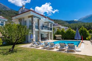 费特希耶Yaşam Park Rena Villaları Ölüdeniz的别墅 - 带游泳池和椅子