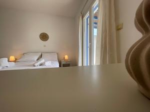 圣彼得罗斯Villa Maniati Studios的客房设有一张床和一张桌子,并带有窗户