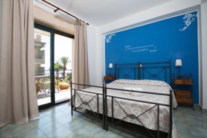 圣阿莱西奥·希库洛唐娜·罗萨酒店的一间卧室配有一张蓝色墙壁的床
