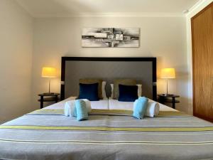 Mexilhoeira GrandeFlor da Primavera by CORAL的一间卧室配有一张带蓝色枕头的大床