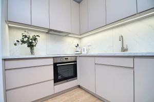 卡托维兹Apartament, Ceglana 76, Katowice的白色的厨房,配有白色的橱柜和花瓶