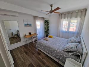 卡帕里卡海岸Amazing Terrace Costa da Caparica的一间卧室配有一张床、一张桌子和一面镜子
