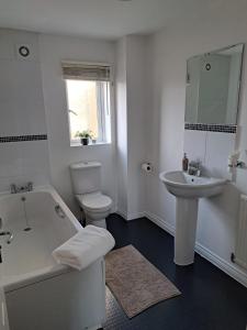 格雷斯瑟罗克Large Bed in a luxuriously furnished Guests-Only home, Own Bathroom, Free WiFi, West Thurrock的白色的浴室设有浴缸和水槽。