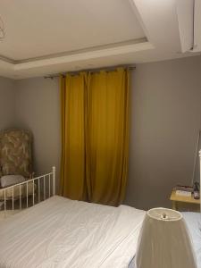 麦地那AlReem Apartment的一间卧室配有床和黄色窗帘