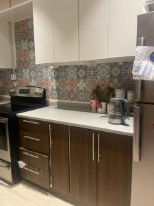 麦地那AlReem Apartment的厨房配有白色橱柜和黑炉。