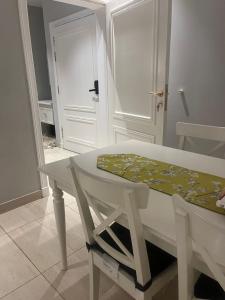 麦地那AlReem Apartment的一间有门的房间,一张白色的桌子和椅子