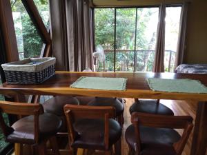 蒙泰韦尔德哥斯达黎加Quality Cabins Monteverde的餐桌、椅子和大窗户