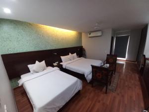 卡拉奇Hira Guest House的酒店客房,配有两张床和椅子