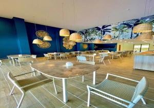 塔曼达雷FLAT 227 l Eco Resort - Praia dos Carneiros - Ao lado da Igrejinha的用餐室配有桌椅和壁画
