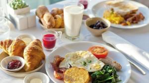 沃迪切Refresh Boutique Suites - Central Point的餐桌上摆放着早餐食品和牛奶盘