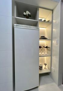 坎波斯杜若尔当Flat Excepcional no Centro de Capivari的带架子的厨房内的白色冰箱