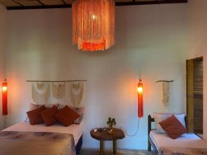 雅帕拉廷加Casa do Francês的一间卧室配有两张床、桌子和灯