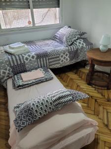 布宜诺斯艾利斯Recoleta Time的客房配有两张带枕头和桌子的床。